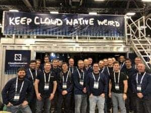 Gentlemen taking picture in front of keep cloud native weird banner