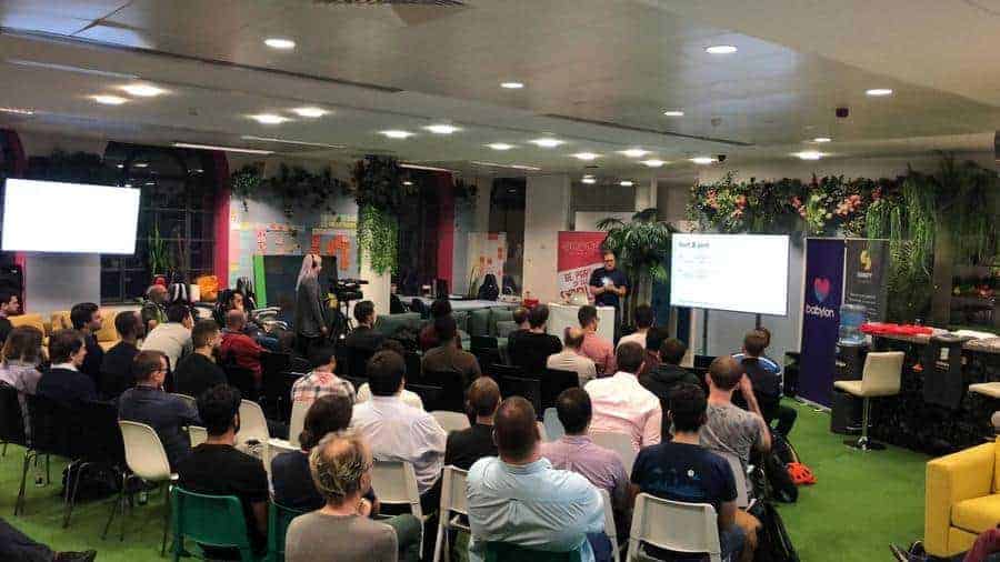 Babylon office with greeneries set up, a gentleman presenting a presentation in front of audience