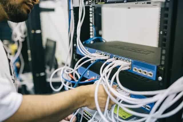 A gentleman fixing cables on server