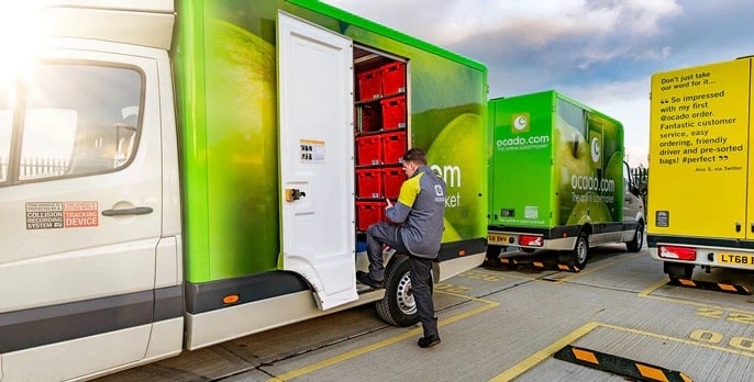Ocado delivery trucks with a delivery guy entering the car