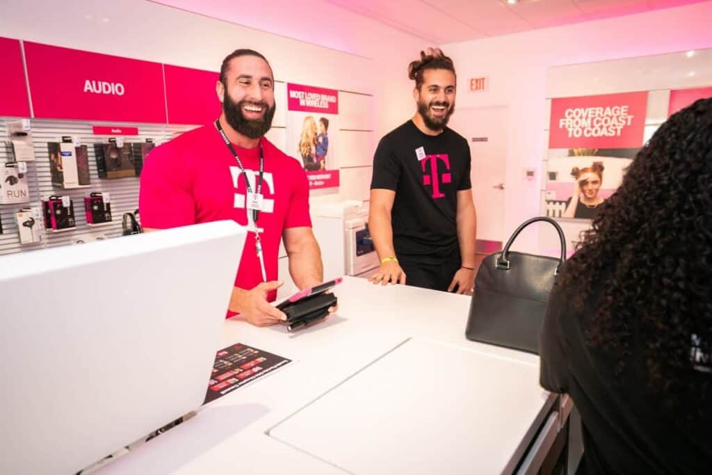 T-Mobile staff happily assisting customer in the store