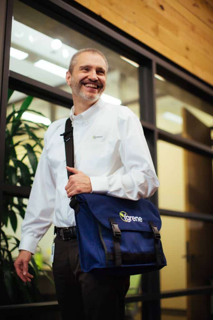 A gentleman smiling carrying Ygrene postman bag
