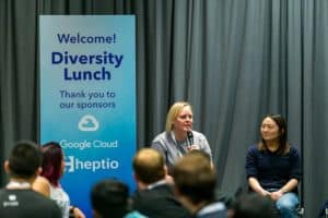 Two ladies talk in front of audience representing Google and Heptio for diversity lunch event