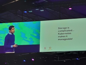 A gentleman presenting on a stage discussing about "Storage is complicated. Kubernetes makes it manageable!"
