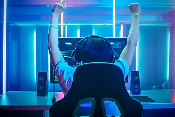 One gentleman (gamer) raising his hands up cheering for his victory