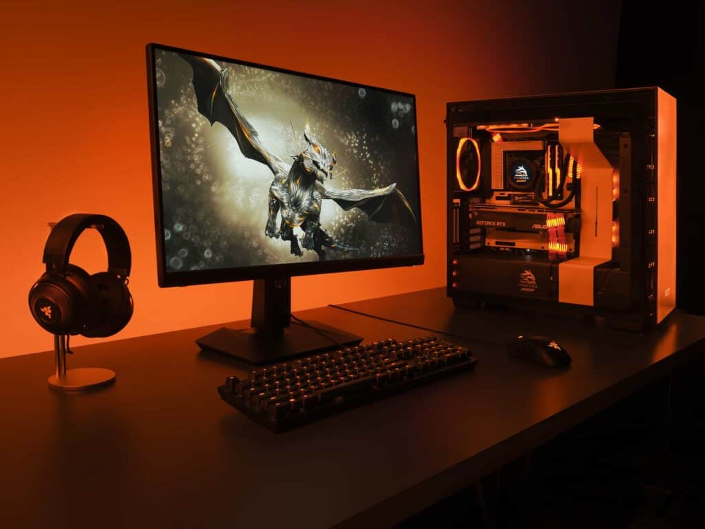 Gaming computer set up with headphones, monitor, keyboard and CPU under orange lights