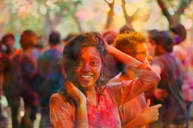 Woman celebrating Holi with red powder on her face