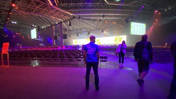 A gentleman in mask posing showing his back in KubeCon + CloudNativeCon Europe 2022 hall