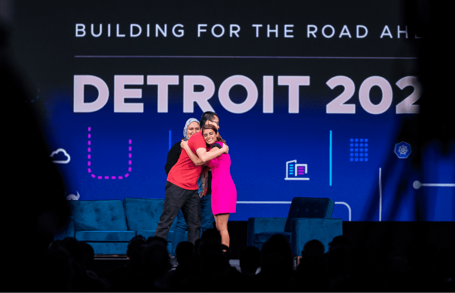 Priyanka Sharma give a gentleman a hug on KubeCon + CloudNativeCon North America 2022 event stage