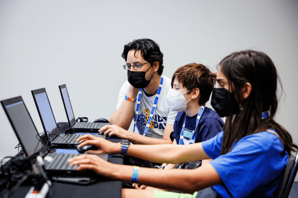 Man and children on laptops