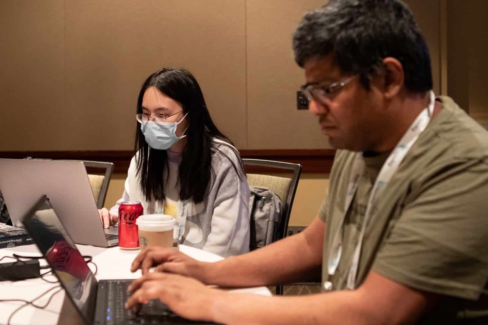 A lady and gentleman working on their computer in conference hall