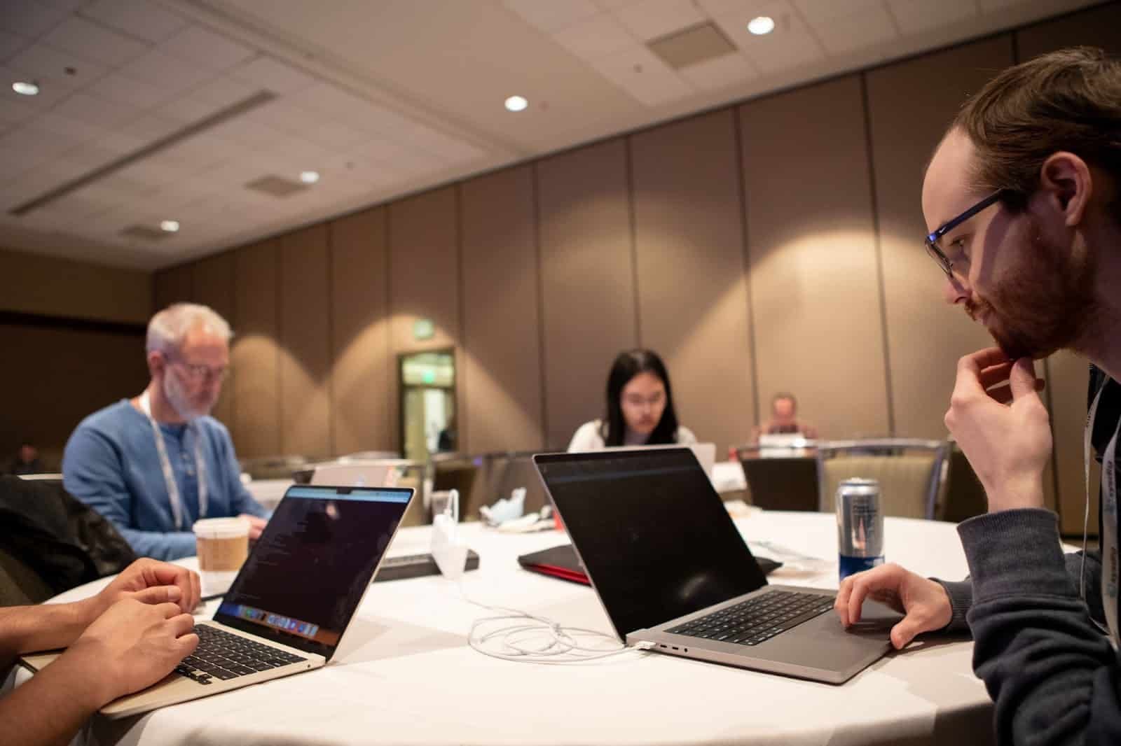 A lady and gentleman sitting in round table working on their computers