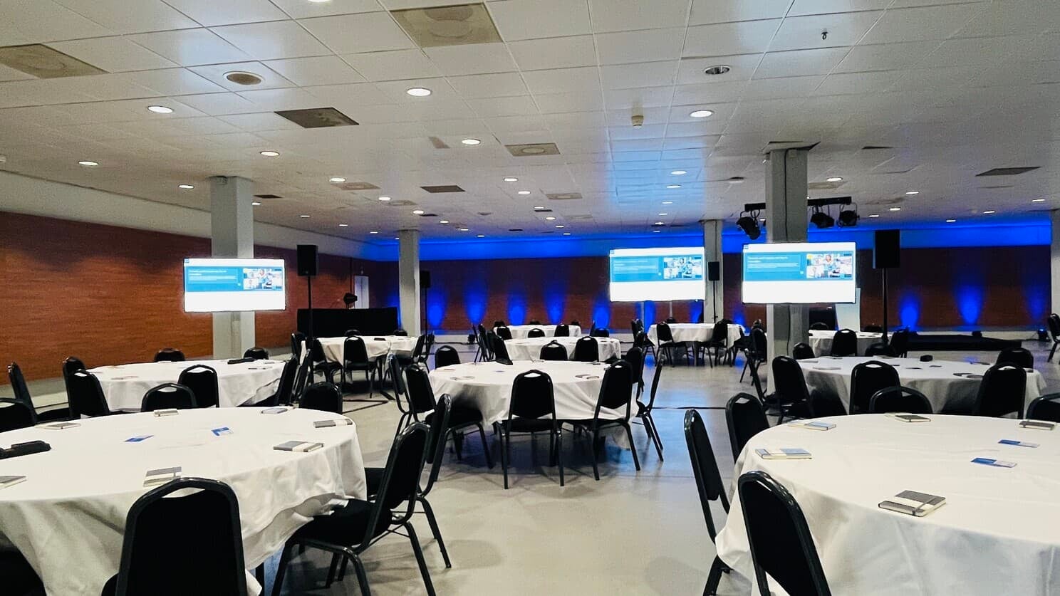 KubeCon + CloudNativeCon Europe 2023 event space with round table and notebook on each seats