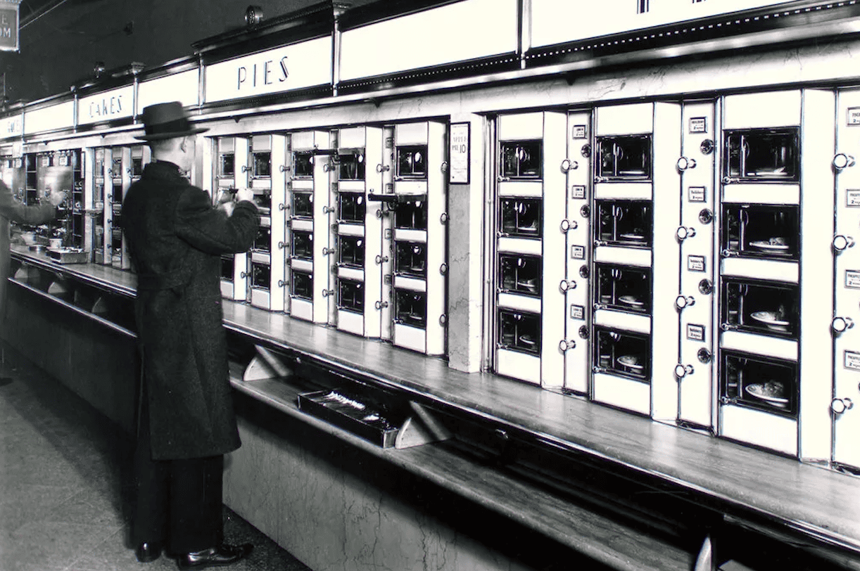 A gentleman in hat standing in front of pies counter