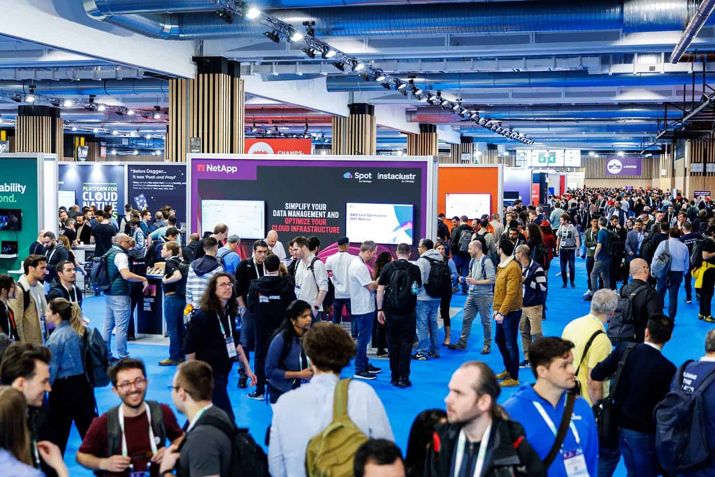 A hall filled with participants networking with some sponsor event booth