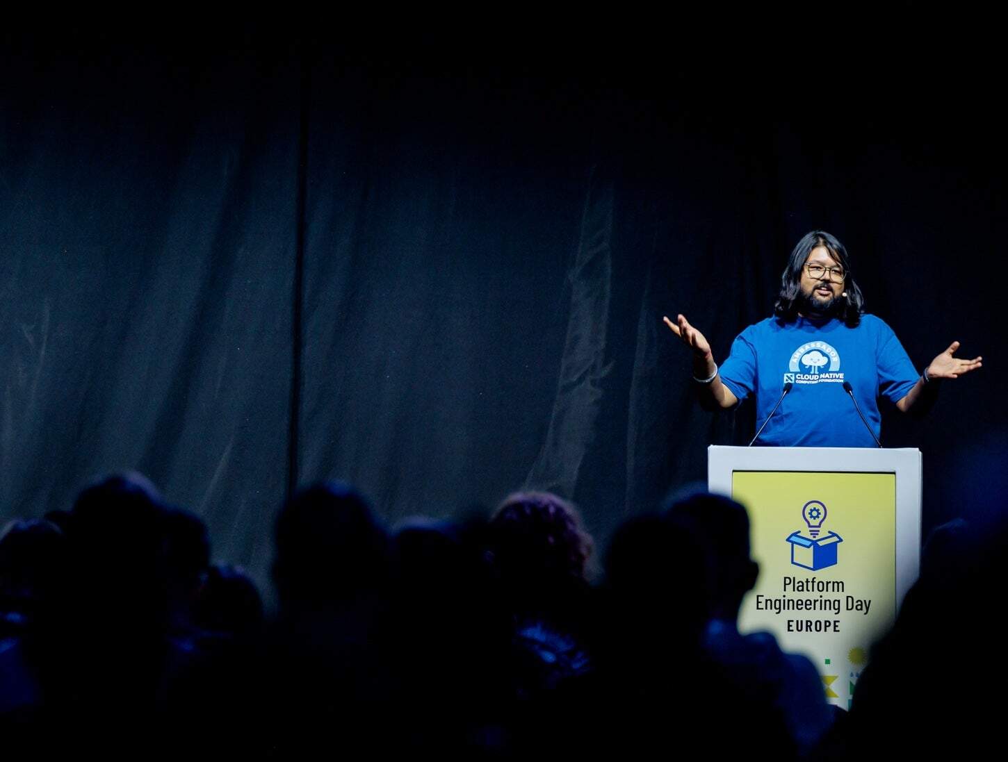 a man on stage giving a talk