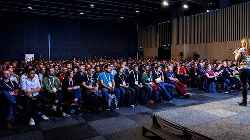 Whitney speaking in front of a large audience.