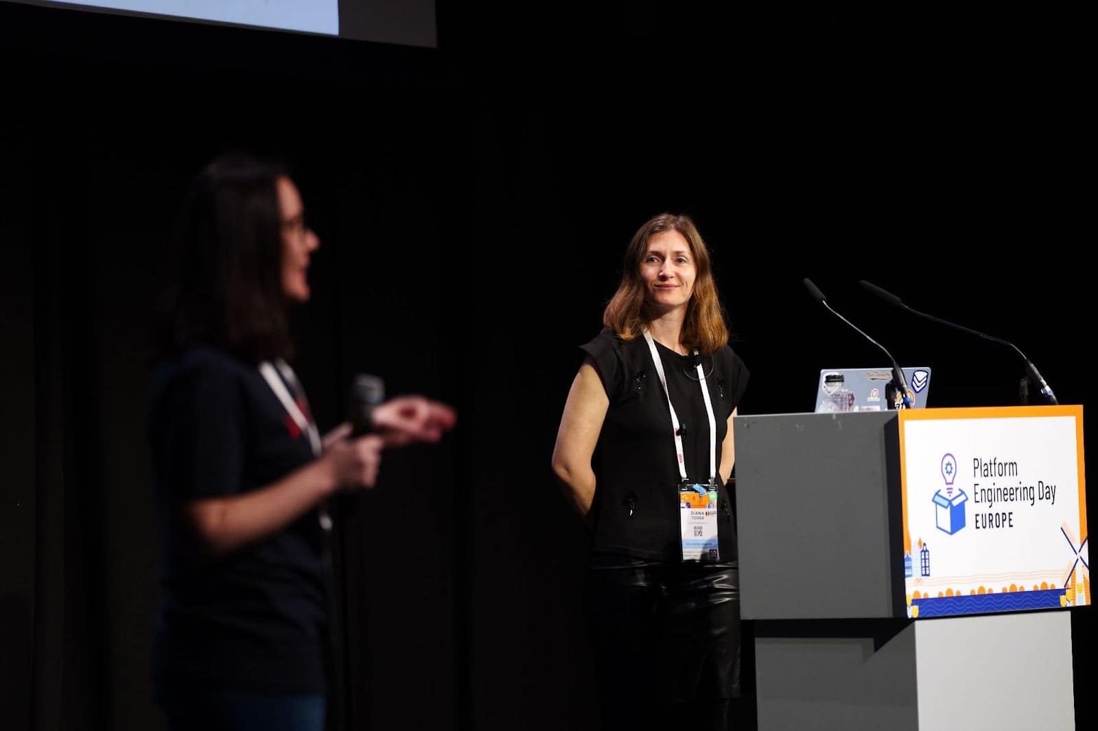 A photo of author Diana Todea, DevRel Engineer at VictoriaMetrics, presenting onstage at Platform Engineering Day Europe