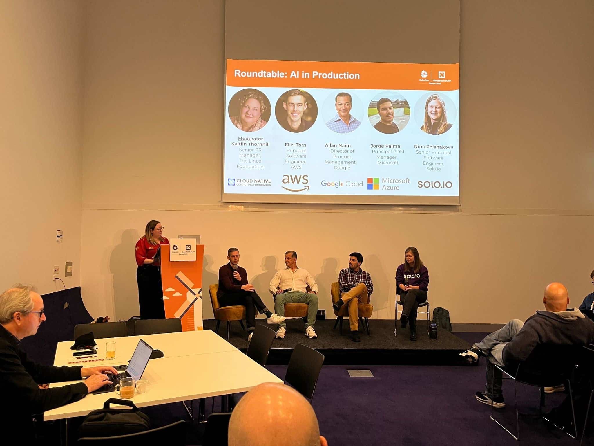 A photo still of the AI in Production Roundtable, featuring moderator Kaitlin Thornhill (far left) and four panelists: Ellis Tarn of AWS, Allan Naim of Google Cloud, Jorge Palma of Microsoft, and Nina Polshakova of solo.io